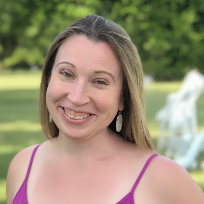 image of woman shoulders up with greenery in the background